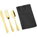 A gold Visions heavy weight spoon, fork, and knife next to a black napkin.
