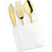 A white napkin with a Visions gold spoon, fork, and knife nestled inside.