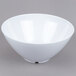 A white bowl with a lid on a gray surface.