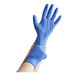 A person wearing blue Noble Nitrile gloves.
