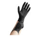A person wearing black Noble NexGen biodegradable nitrile gloves.