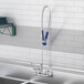A Waterloo wall-mounted pre-rinse faucet with an add-on faucet and hose.