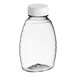 An 8 oz. clear PET Classic Queenline honey bottle with a white flip top lid.