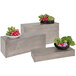 A Cal-Mil rectangular pine display riser with wooden boxes of vegetables on a table.