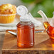 A 8 oz. Skep PET sauce/honey bottle with a white plastic flip top lid with a small hole.