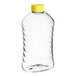 A clear ribbed PET plastic honey bottle with a yellow cap.