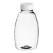 A clear plastic Classic Queenline honey bottle with a white flip top lid.