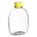 A 16 oz. clear PET Queenline honey bottle with a yellow cap.