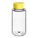 A clear plastic Cylinder PET sauce bottle with a yellow cap.