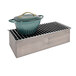 A gray metal grate with a green pot on top.