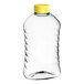 A clear plastic Ribbed Hourglass PET honey bottle with a yellow cap.
