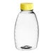 A Classic Queenline PET clear plastic honey bottle with a yellow cap.