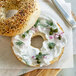 A sesame seed bagel with Violife Just Like Cream Cheese on it.