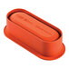 An orange silicone baking mold for an oval cake on a kitchen counter.