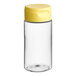 A clear plastic cylinder sauce bottle with a yellow lid.