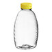 A clear plastic Classic Queenline honey bottle with a yellow cap.