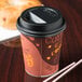 A close-up of a Solo black plastic travel lid on a coffee cup.