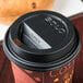 A close-up of a Solo black plastic travel lid on a coffee cup.