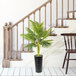A 48" artificial palm plant in a black ribbed metal planter next to a wooden staircase.