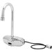 A T&S silver wall mount sensor faucet with a black cord.