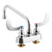 A T&S chrome deck mount faucet with wrist action handles and a swing nozzle.