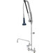 A silver T&S deck mount pre-rinse faucet with a black handle and a pull-down sprayer.