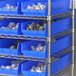 A metal shelf with Regency blue plastic bins.