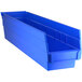 A Regency blue plastic shelf bin with two compartments.