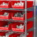 Metal shelves holding Regency red plastic shelf bins.