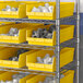 Metal shelving with Regency yellow plastic shelf bins.