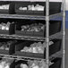 A metal shelving unit with black Regency shelf bins.
