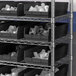 A Regency black shelf bin on a metal shelving unit.
