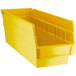 A close up of a yellow Regency plastic shelf bin with two compartments.