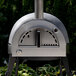 A silver and black Pinnacolo outdoor pizza oven with a round top.