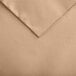 A tan Snap Drape Windsor Damask Sandalwood cloth table cover with folded edges.