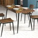 A Lancaster Table & Seating black standard height table base with plates and chairs on it.