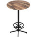 A round wooden Holland Bar Stool EuroSlim bar table with a metal base and foot rest.