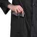 A man holding a black Cordova rain coat with a pocket.