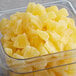 A container of dehydrated pineapple chunks on a table.