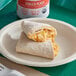 A Los Cabos egg and cheese breakfast burrito on a plate.