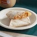 A Los Cabos cheese, egg, and sausage breakfast burrito on a white plate.