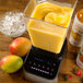 A blender with Smartfruit Mellow Mango Puree in it.