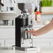 A person using a HeyCafe Allround coffee grinder on a counter.