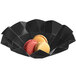 A Solia black cardboard bowl with a colorful macaroon inside.