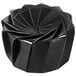 A black Solia cardboard origami bowl with a spiral design on it.