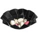 A Solia black cardboard bowl with white and pink pebbles inside.