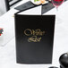 A black Menu Solutions wine list cover on a table.