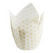 A white paper baking cup with gold tulip print.