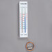 A Taylor indoor/outdoor thermometer with a wire attached.
