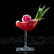 A glass with a red drink and a rose petal with a HAY! Wheat straw in it.